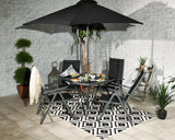Black garden furniture set with round glass table, chairs, umbrella and geometric rug