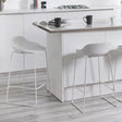 White bar stools with low backs and metal legs at a modern kitchen island