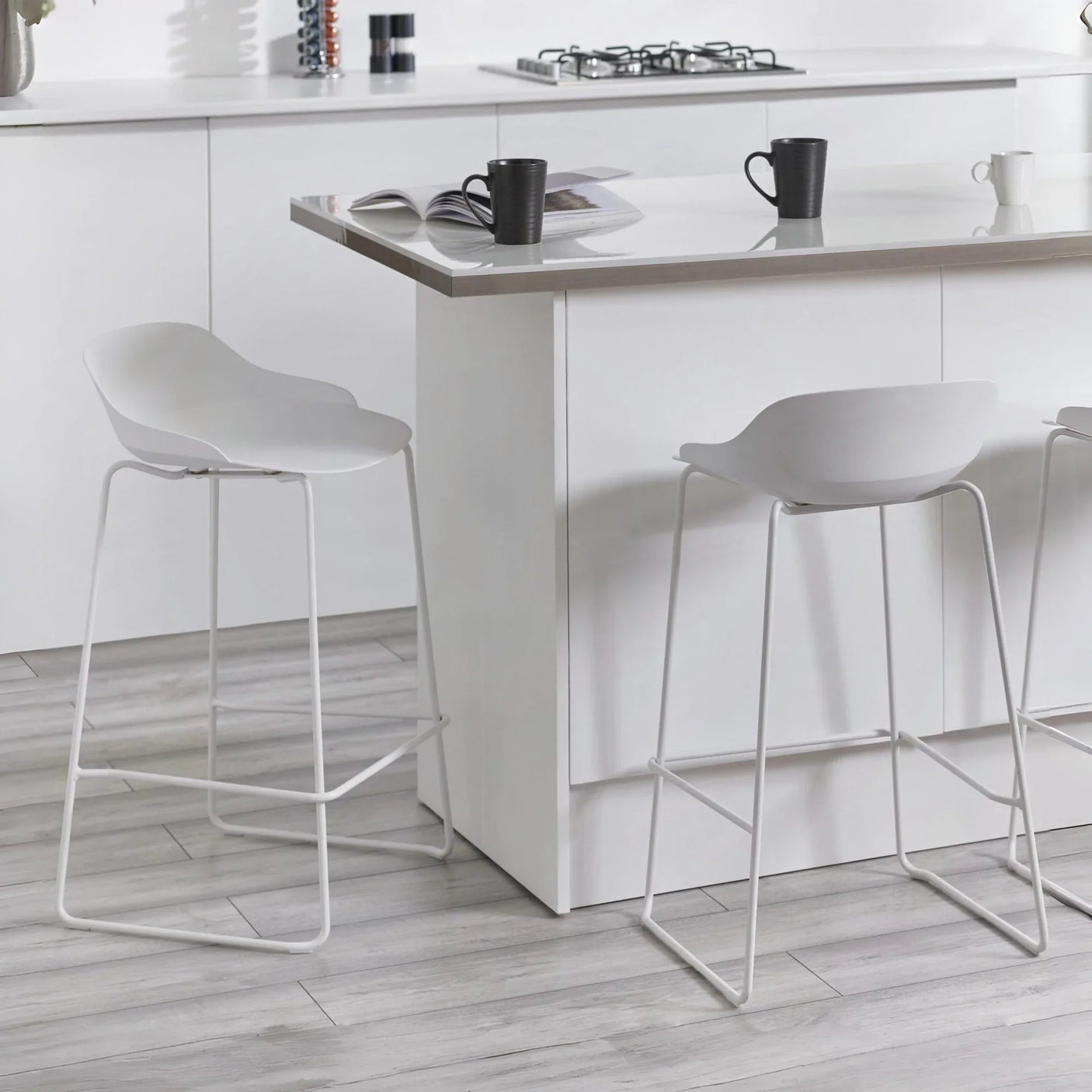White bar stools with low backs and metal legs at a modern kitchen island
