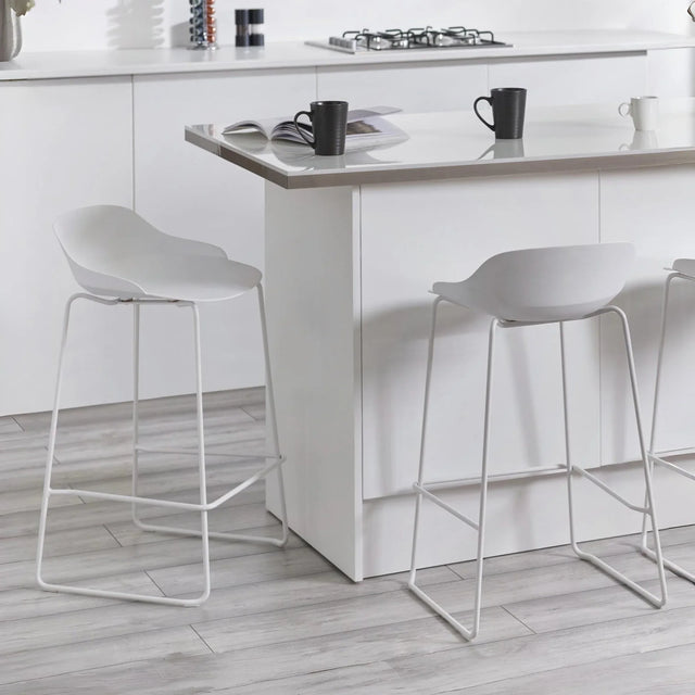 White bar stools with low backs and metal legs at a modern kitchen island