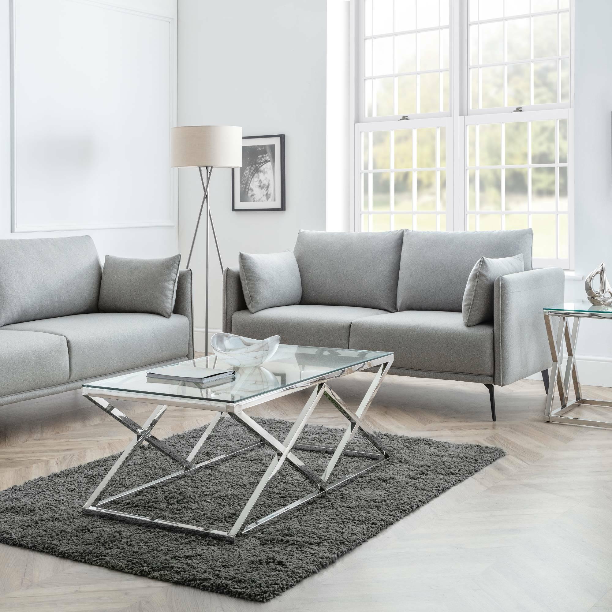 Grey fabric 2 seater and 3 seater sofas with glass coffee table in bright living room