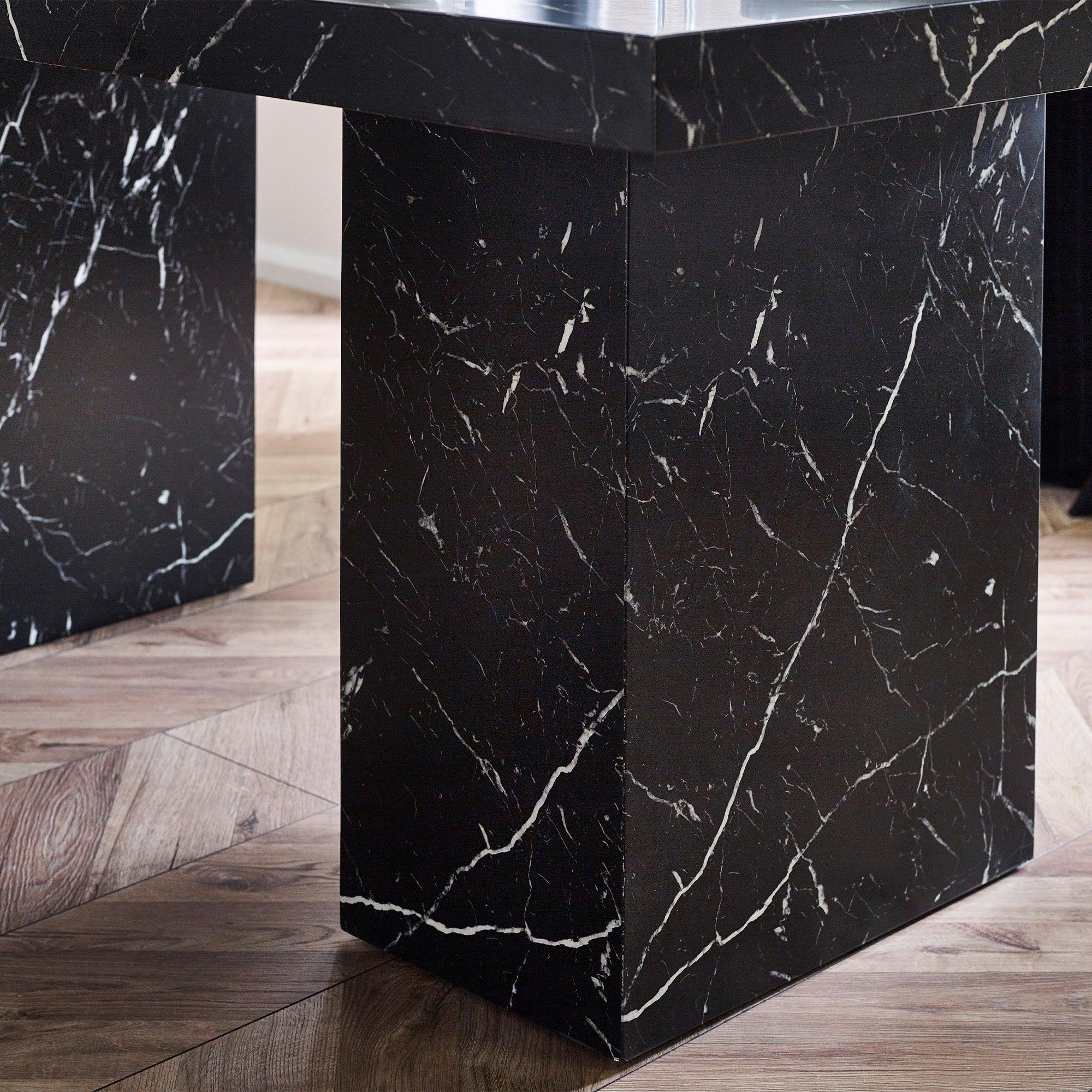 Black marble effect dining table base with white veining on wood floor