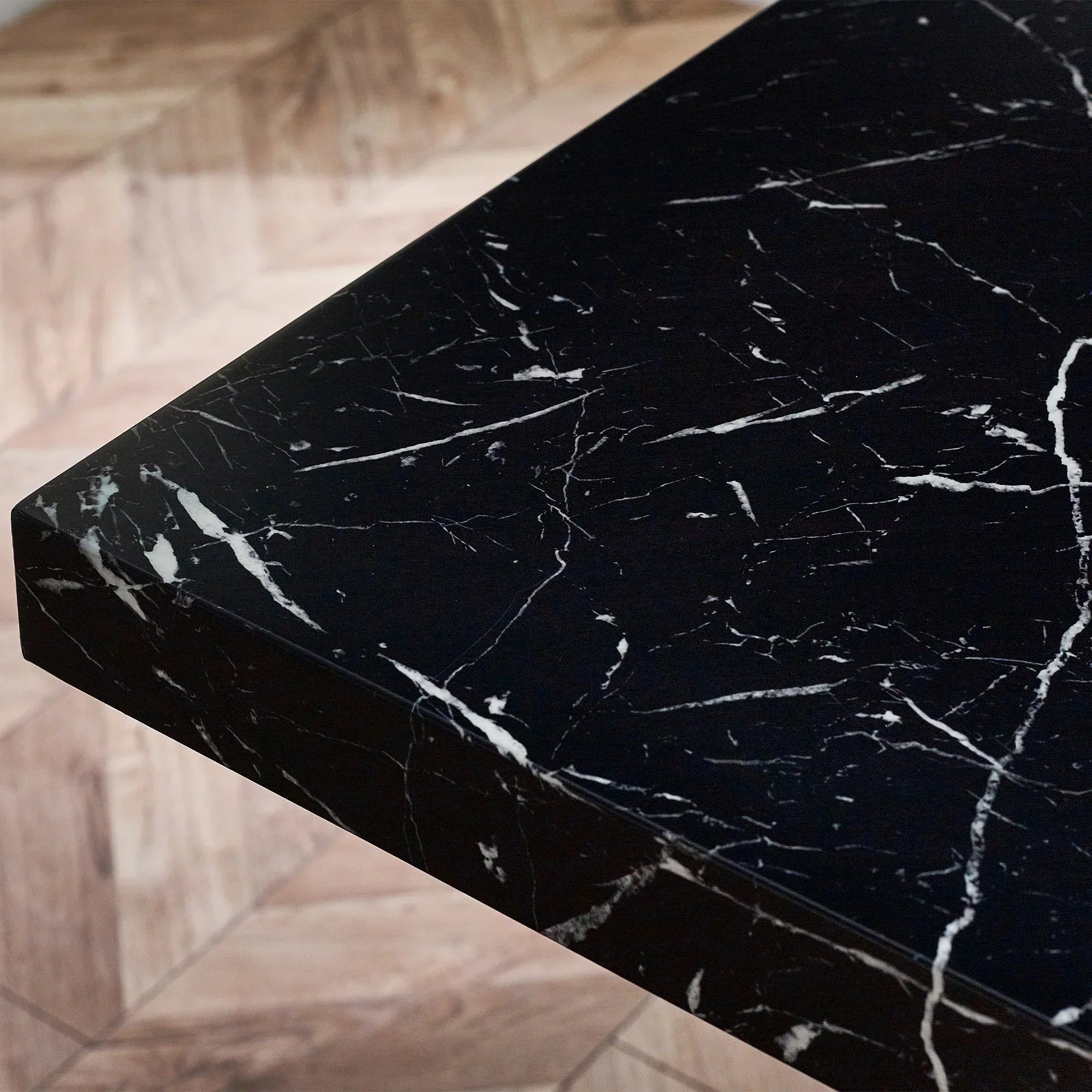Black marble effect dining table top with white veining, close-up of corner detail