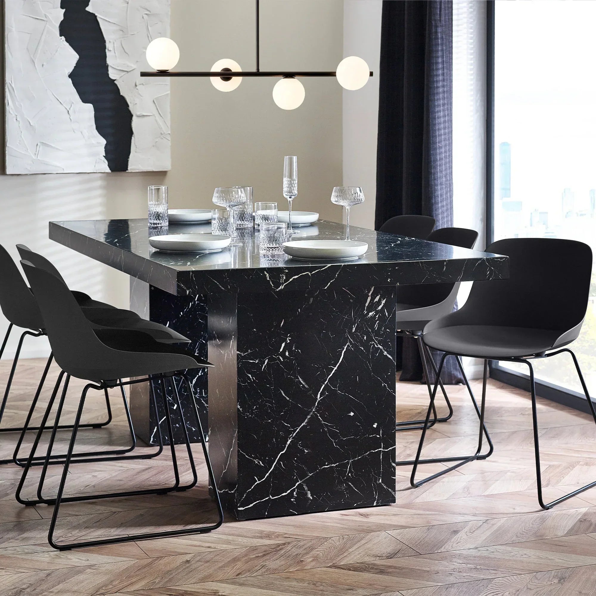 Black marble effect dining table with six black chairs in modern dining room setting