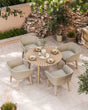 Beige rattan garden dining set with round wooden table and four cushioned chairs on patio