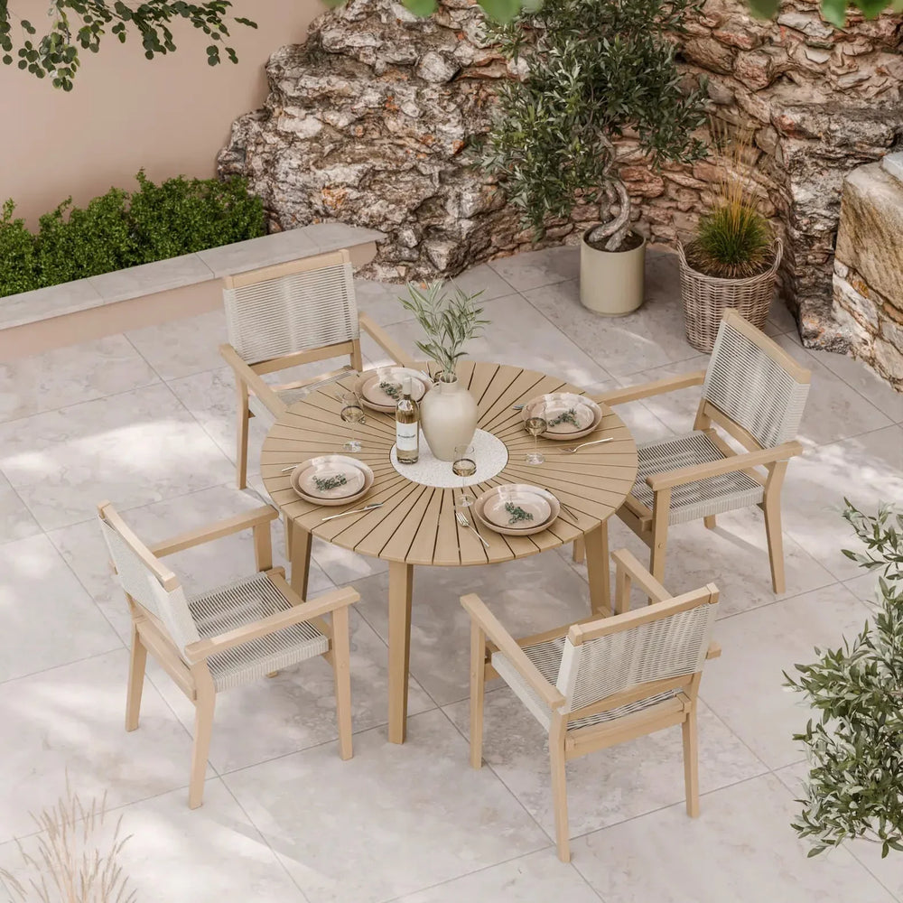 Round wooden outdoor dining set with four chairs on tiled patio, set for four people
