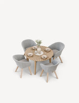 Round wooden dining table with four grey woven chairs set for a meal
