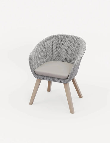 Grey rattan dining chair with beige cushion and light wood legs on white background