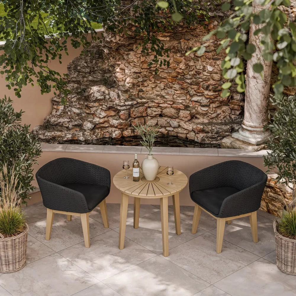 Outdoor bistro set with round wooden table and two black rattan chairs on tiled patio