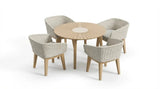 Round wooden dining table with four woven rattan armchairs and light seat cushions