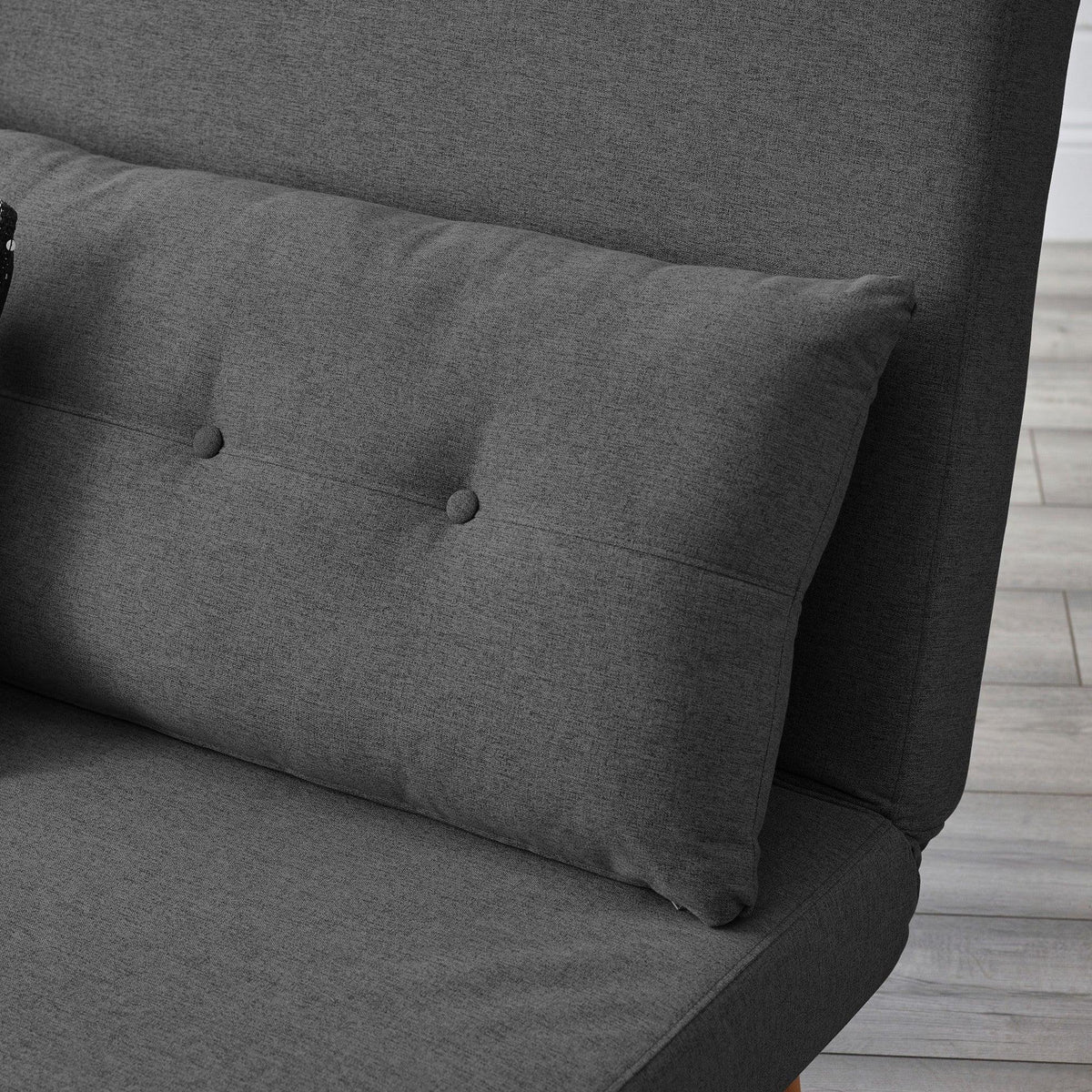 Mid grey single sofabed with buttoned cushion and upholstered fabric close-up