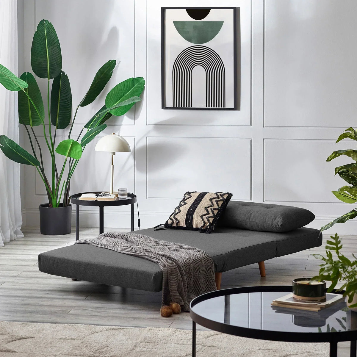 Mid grey single sofabed in modern living room with plants and geometric wall art