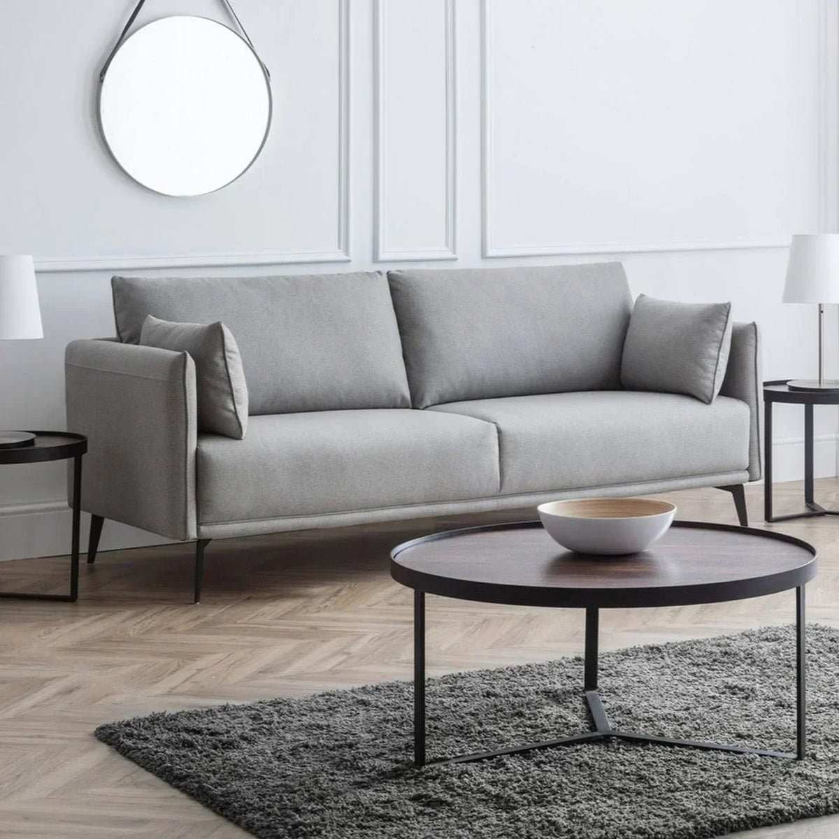 Grey three seater sofa with slim arms in modern living room with walnut coffee table and rug