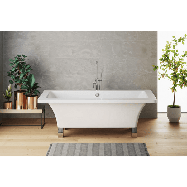 Modern freestanding bathtub in a bathroom with plants and a gray wall.