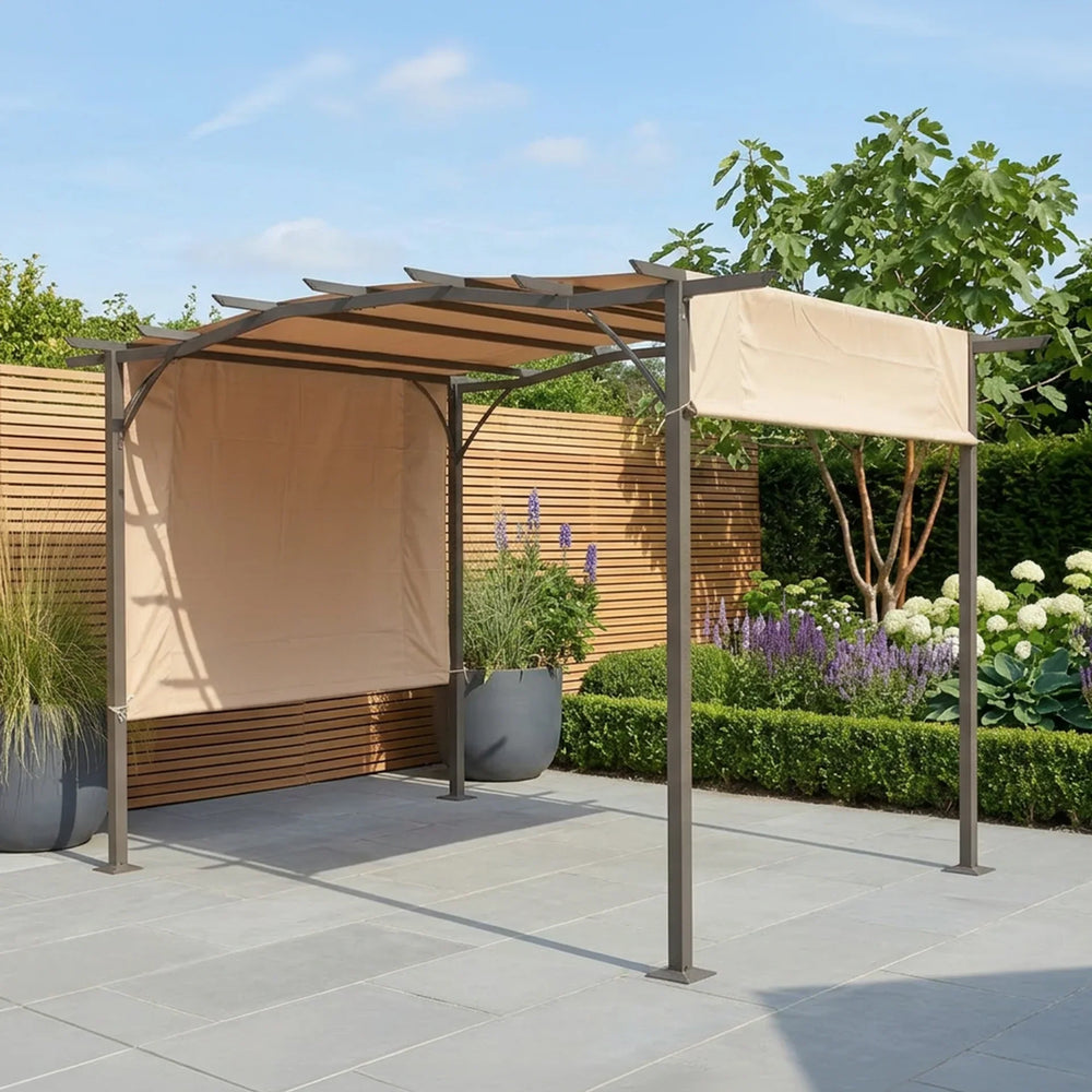 Metal garden pergola with beige fabric canopy on stone patio, surrounded by plants and flowers