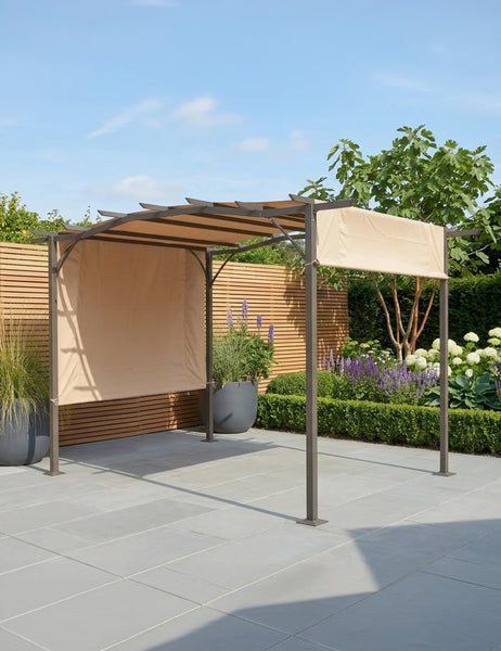 Metal garden pergola with beige fabric canopy on stone patio, surrounded by plants and flowers