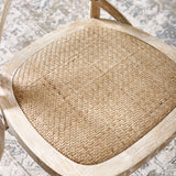 Close view of cane seat with woven pattern framed in light wood with whitewashed finish
