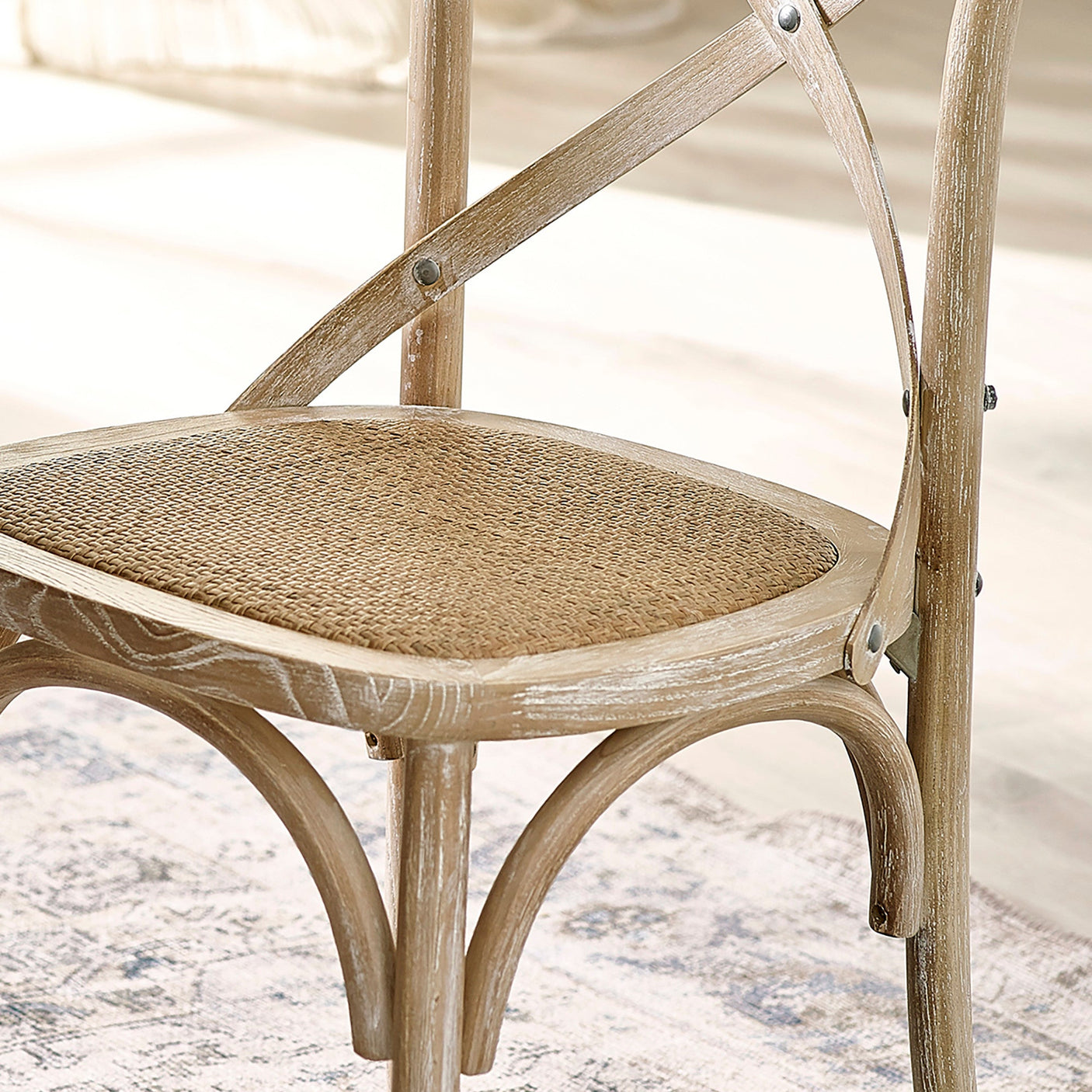 Close-up of light wooden dining chair cane seat with woven texture and curved supports