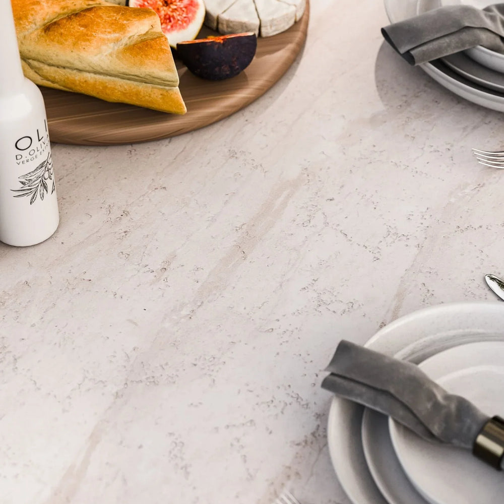 Marble dining table set with plates, cutlery, bread, cheese and figs on wooden platter
