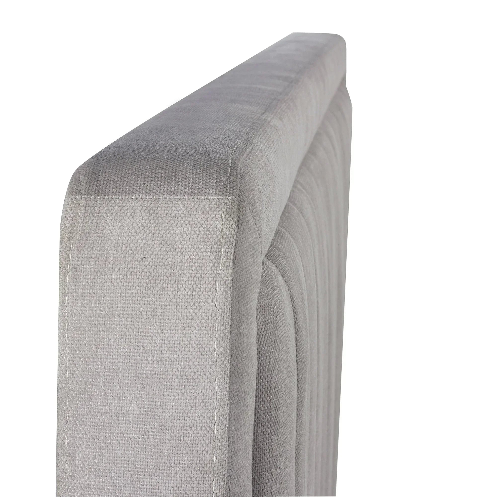 Close detail of grey fabric bed headboard with textured upholstery