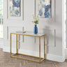 Marble top console table with gold metal frame, blue vase and book in modern hallway