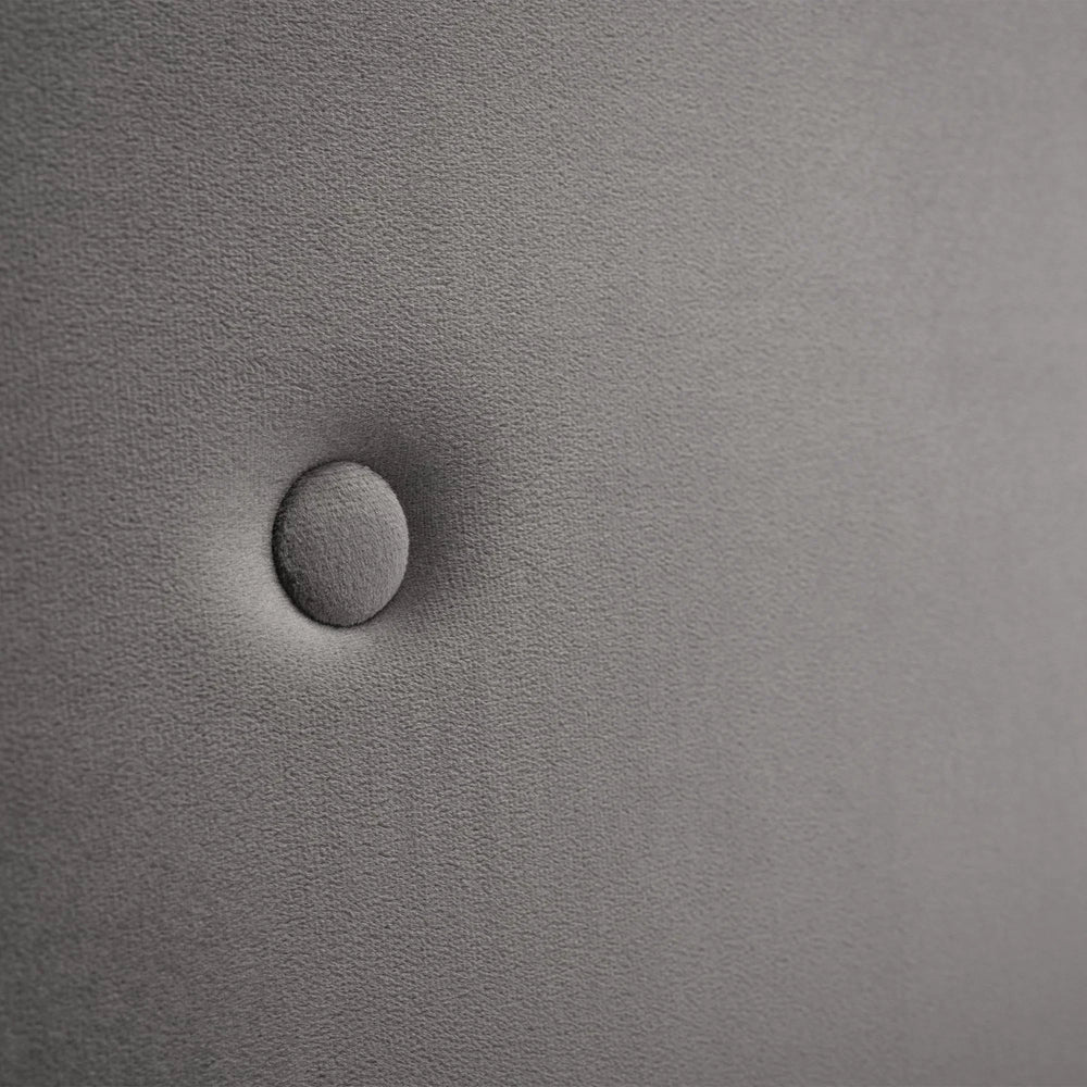 Close-up of grey upholstery on storage bed headboard with button detail