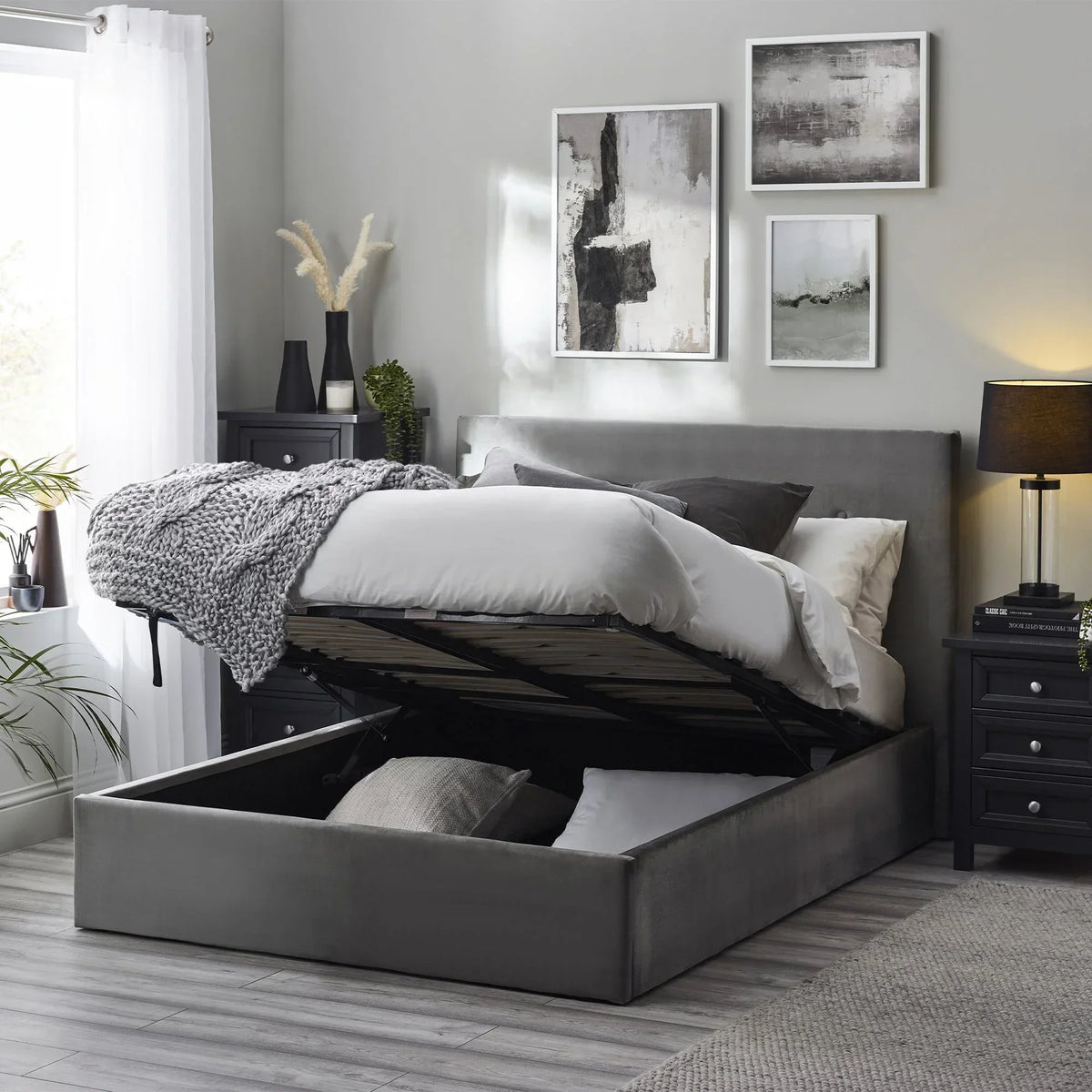 Grey upholstered storage bed with lift-up mattress in modern bedroom setting