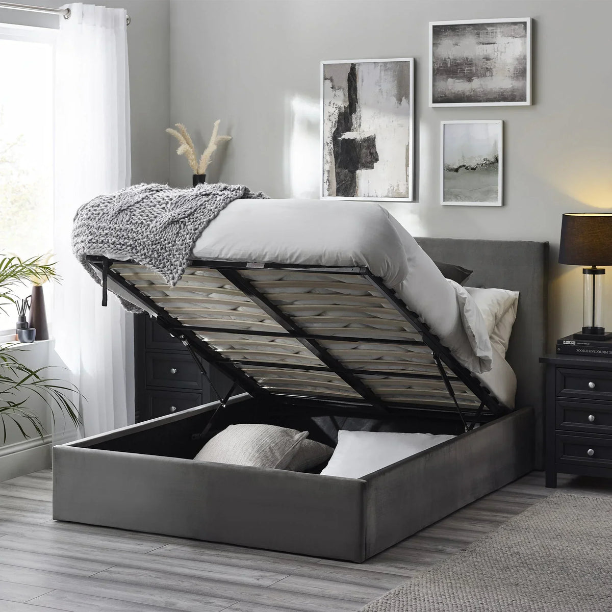 Grey lift-up storage bed with upholstered headboard in modern bedroom setting