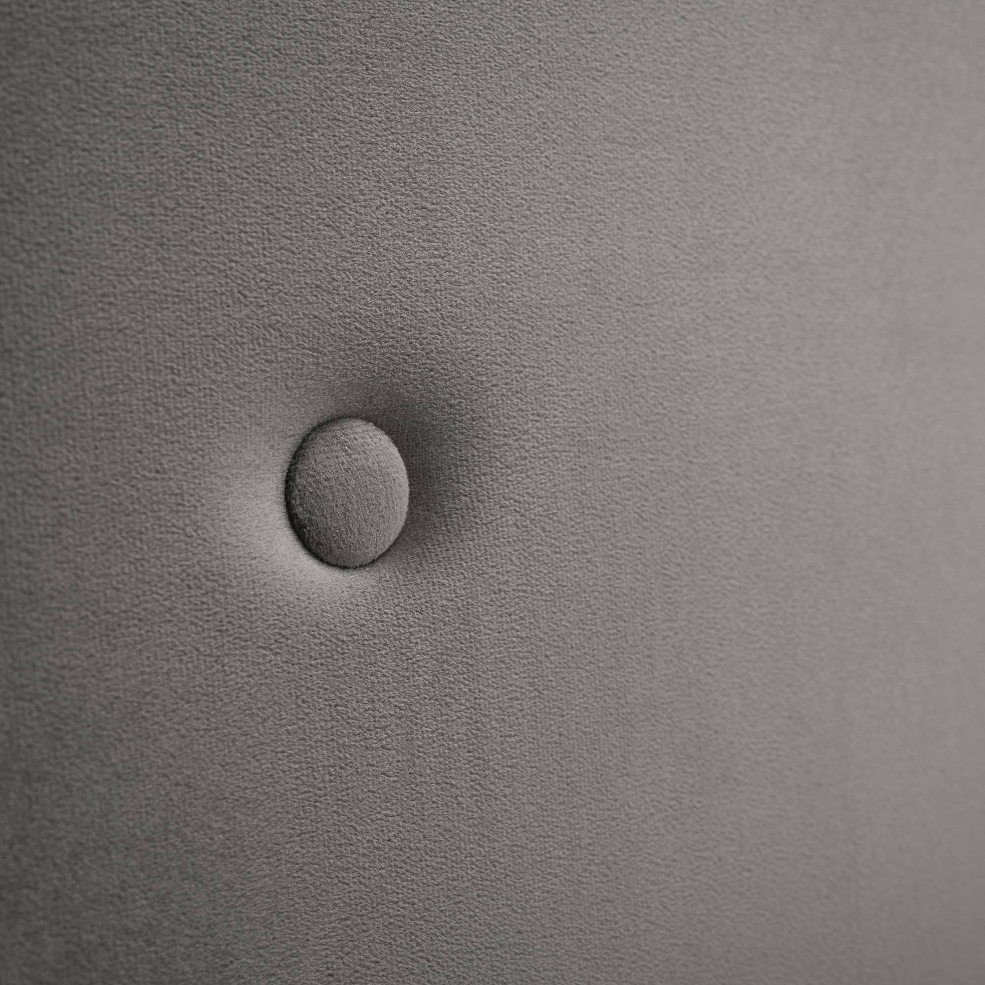 Close up of grey upholstered headboard with button tuft detail