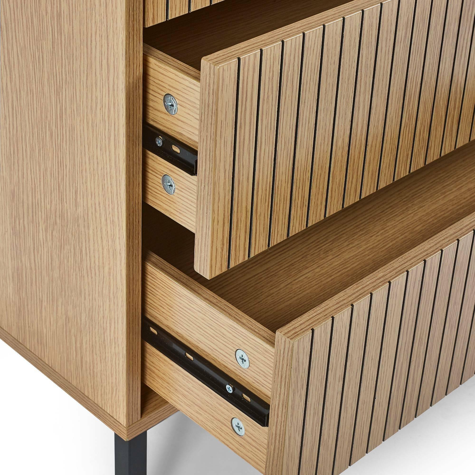 Close-up of wooden chest of drawers with slatted fronts and metal legs