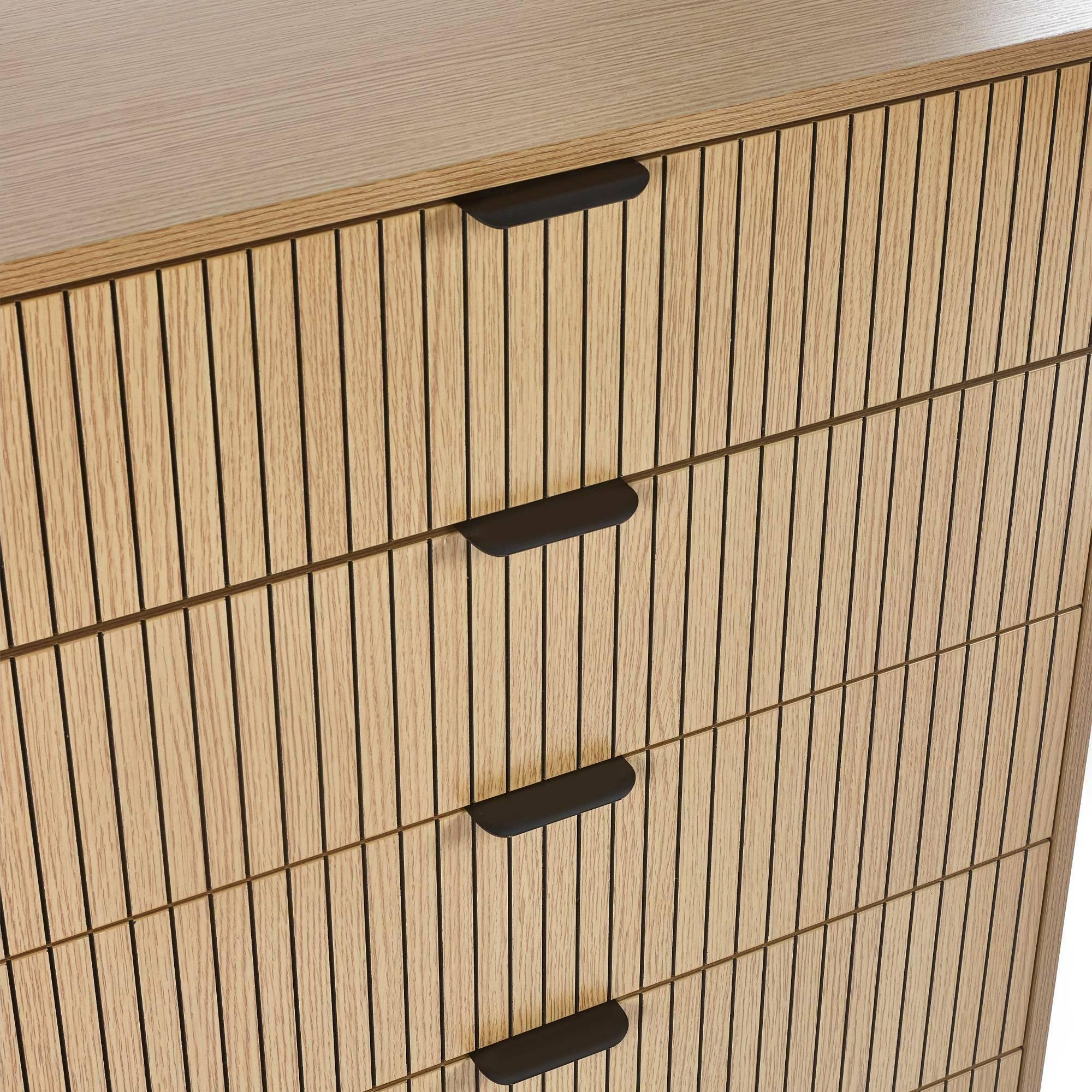 Oak chest of drawers with vertical slatted wood detail and matte black handles