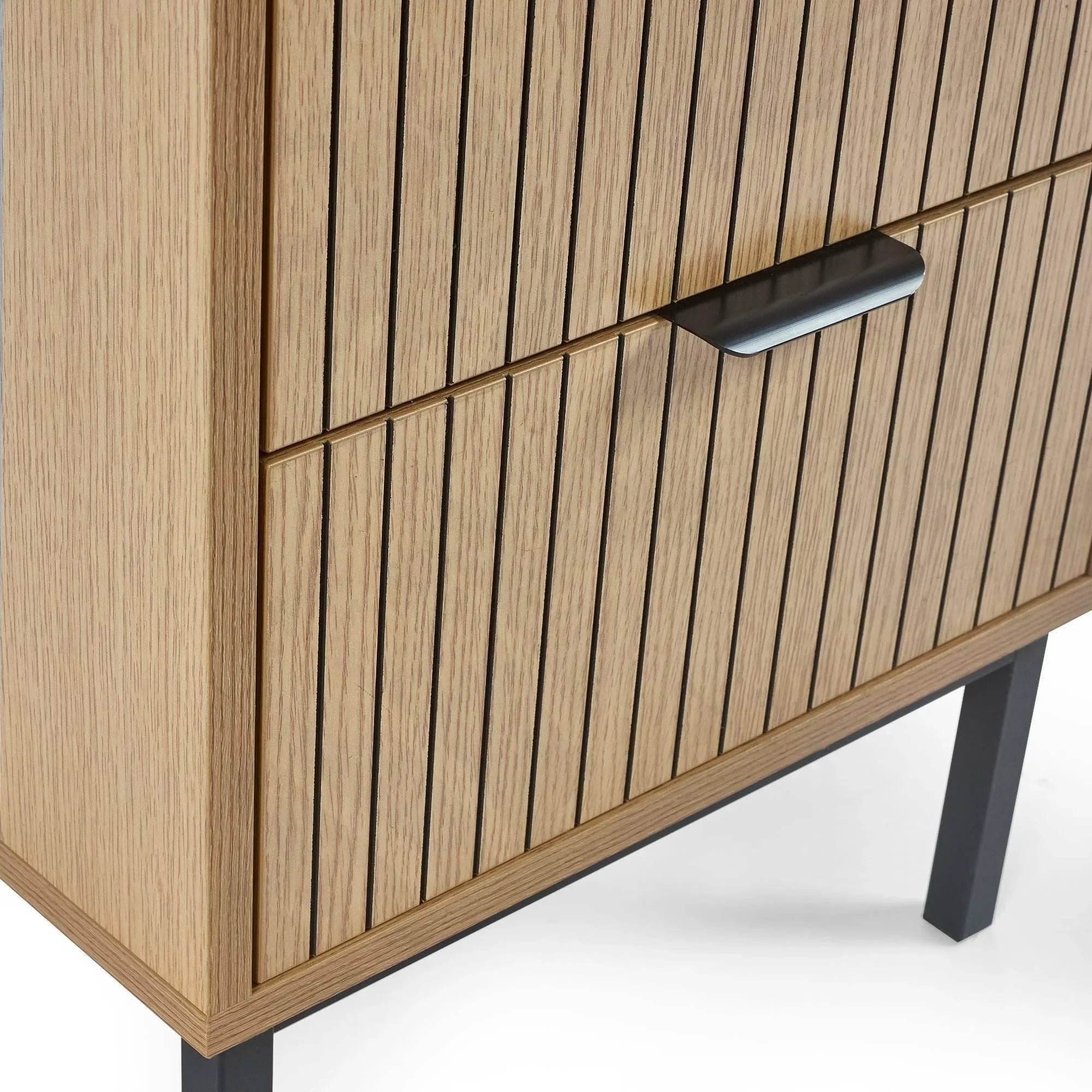 Close-up of wood sideboard with vertical slat detail and black metal handle on drawer