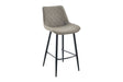 A modern bar stool with a light taupe-gray quilted velvet upholstered seat and backrest, supported by slim black metal legs.