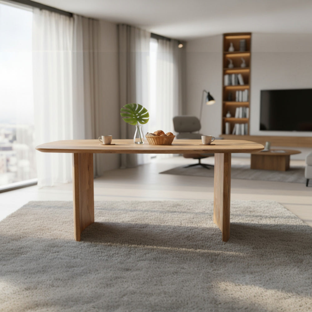 Wooden dining table in a modern living room with a TV and bookshelf in the background.