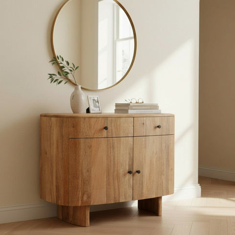 Wooden sideboard with round mirror and decor items in a room.