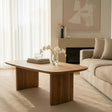 Modern living room with a wooden coffee table, beige sofa, and abstract art on the wall.