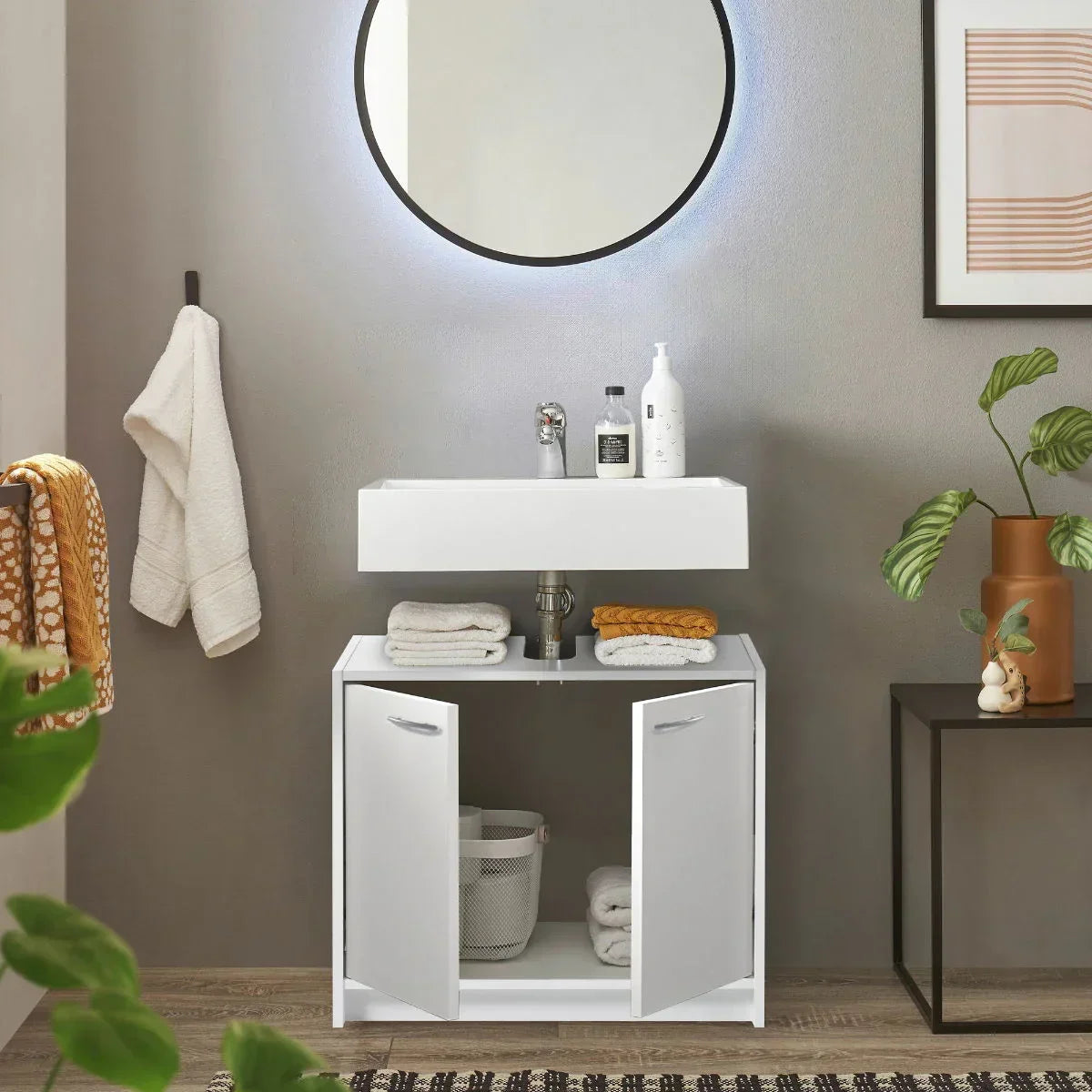 White under sink storage unit with open doors in modern bathroom setting