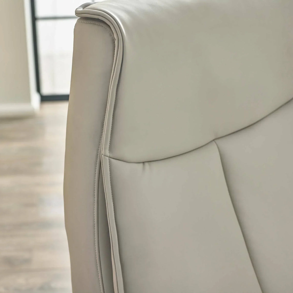 Closeup of light grey Sofia dual recliner backrest with smooth faux leather upholstery