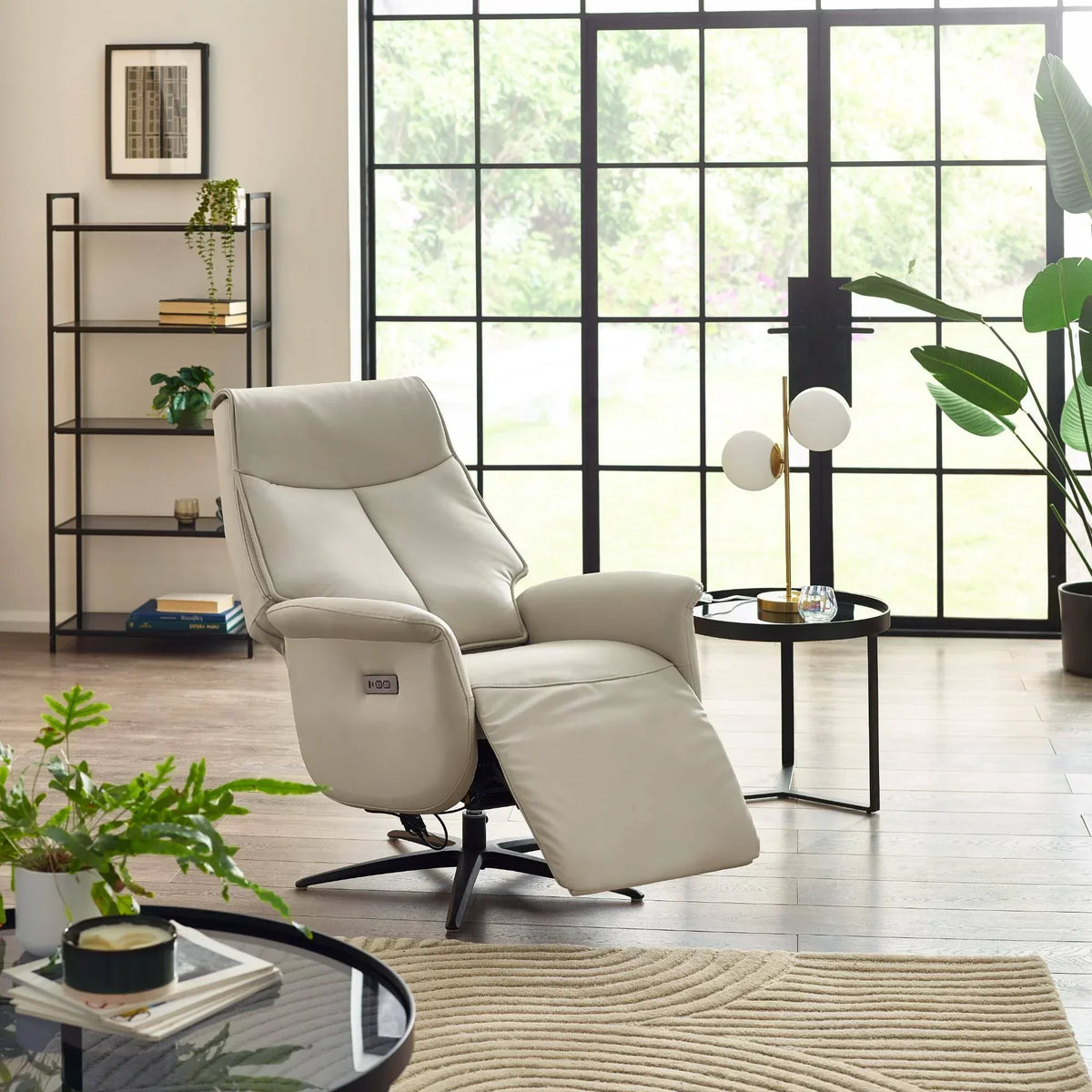 Cream dual recliner chair in bright living room with large windows and indoor plants