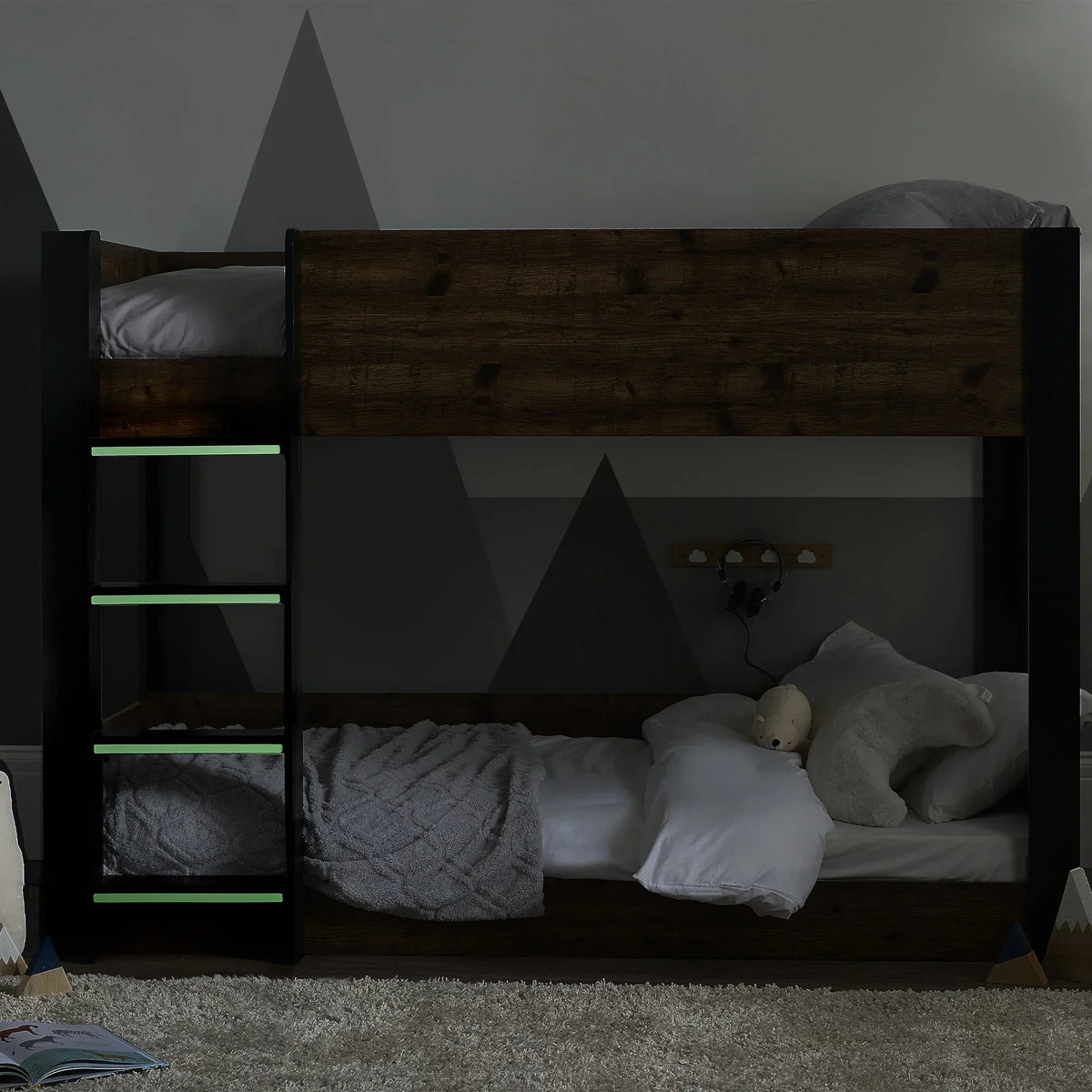 Rustic wood bunk bed with black frame, glow ladder rungs, staged in children’s bedroom