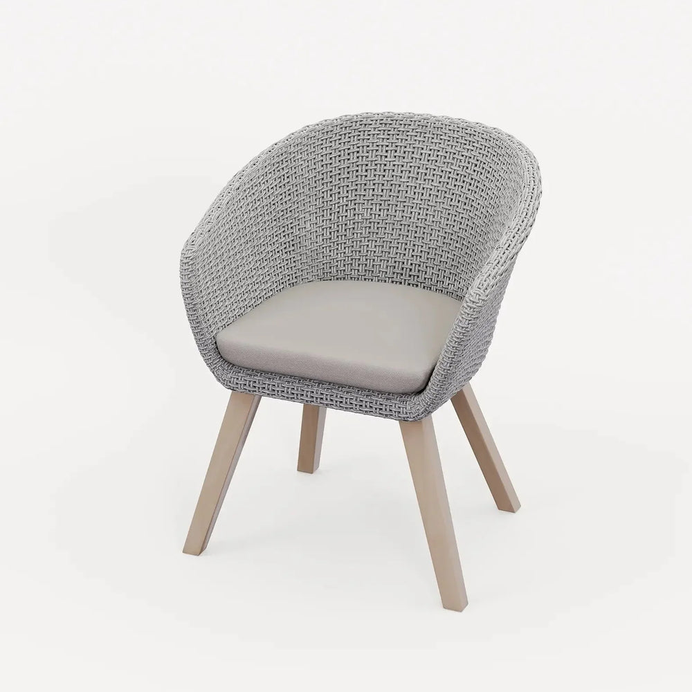 Grey rattan accent chair with curved backrest, light seat cushion, and wooden legs