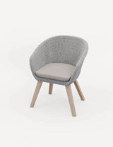 Grey rattan chair with curved backrest, light wood legs and beige seat cushion, front angle