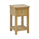 Isolated light oak bedside table with single drawer and open lower shelf, angled front view on white background