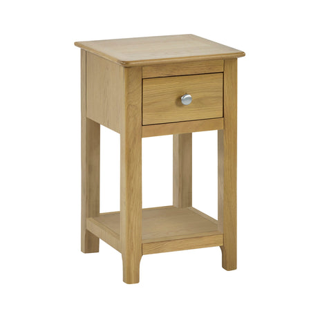 Isolated light oak bedside table with single drawer and open lower shelf, angled front view on white background