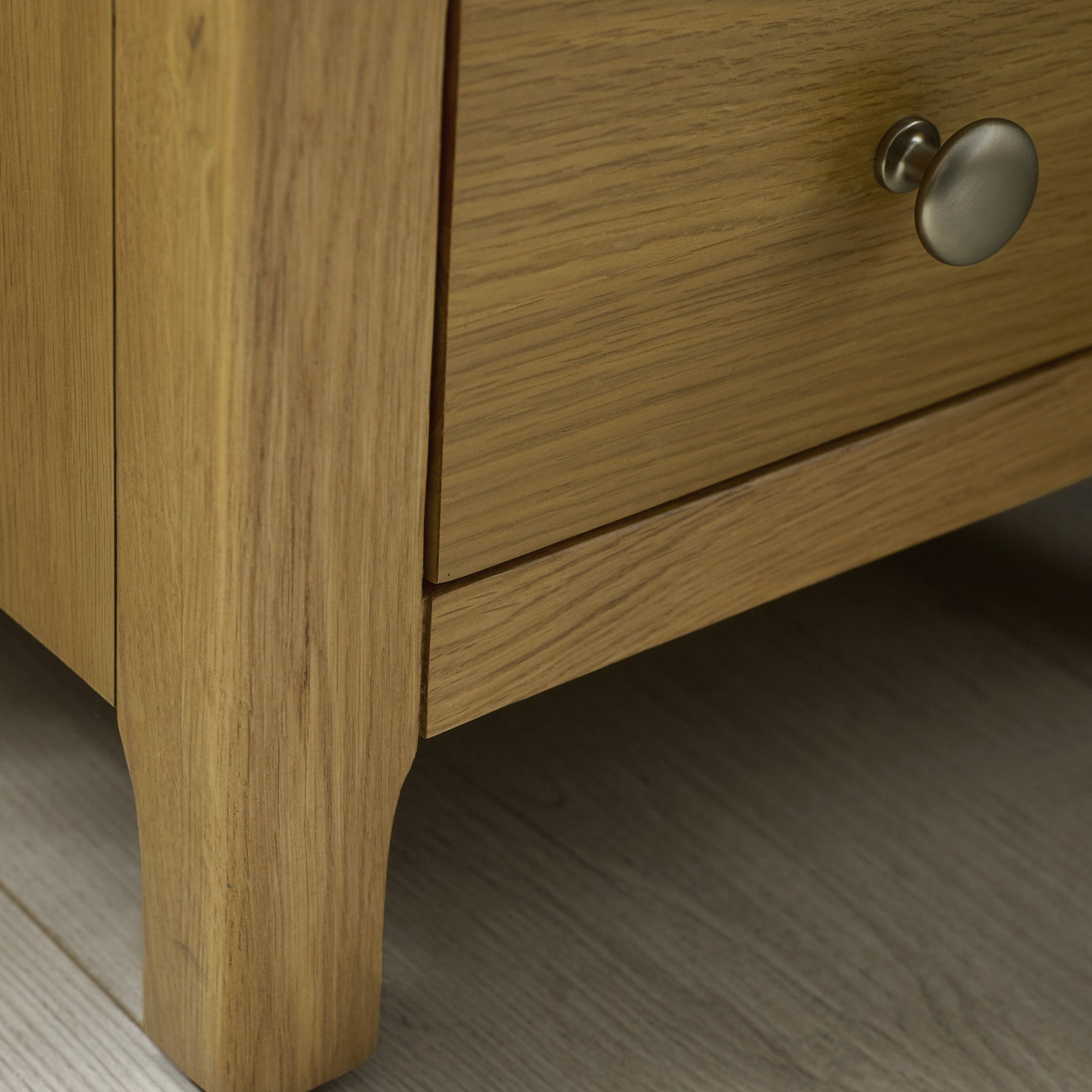 Close-up of the corner and top surface of the light oak bedside table showing wood texture