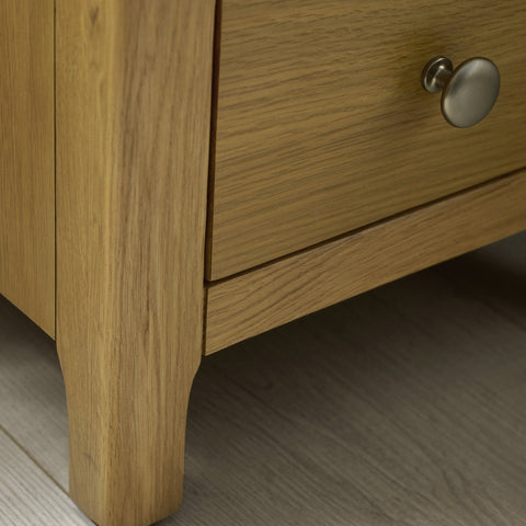 Close-up of the corner and top surface of the light oak bedside table showing wood texture