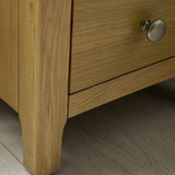 Close-up of the corner and top surface of the light oak bedside table showing wood texture