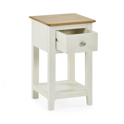 Cream painted bedside table with oak top and open drawer on white background, angled front view