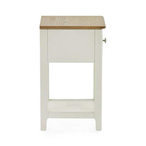 Side view of cream painted bedside table with oak top and closed drawer on white background