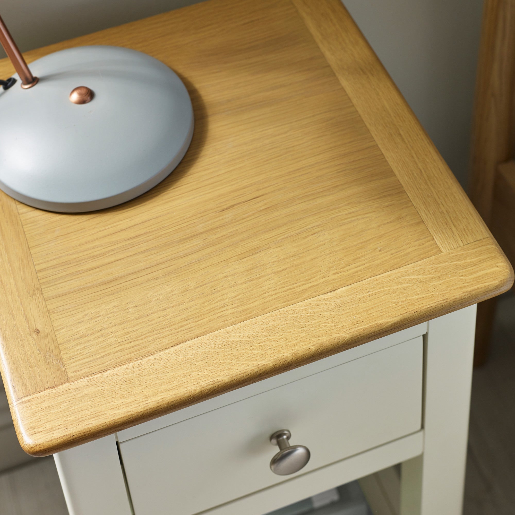 Oak table top with decorative grain and cream painted drawer front with metal knob